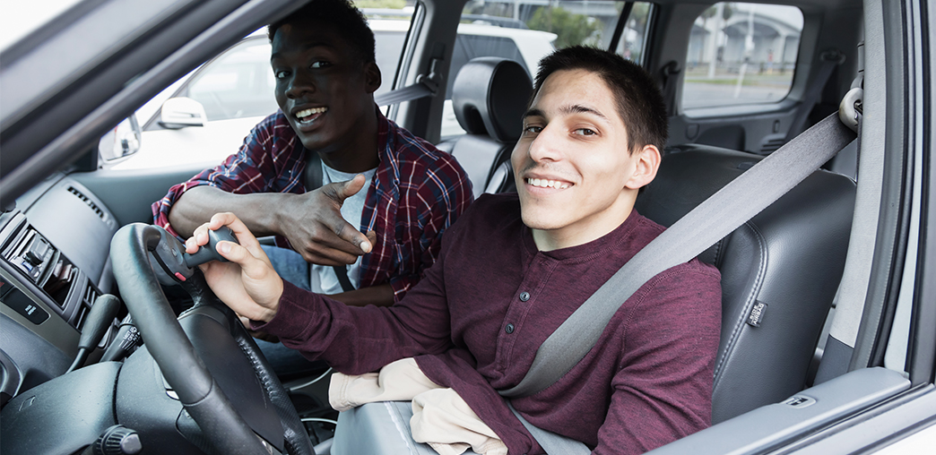 Young male driver whois disabled with a friend looking out the window of their car.