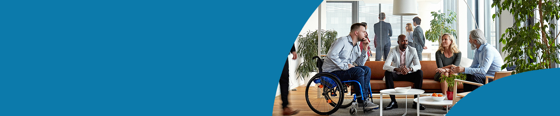 Group of colleagues collaborating the office. One man is using a wheelchair.